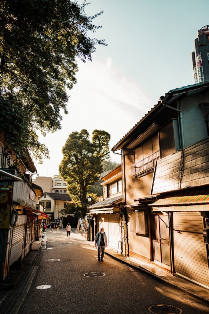 A person walks down a narrow street lined with shops.