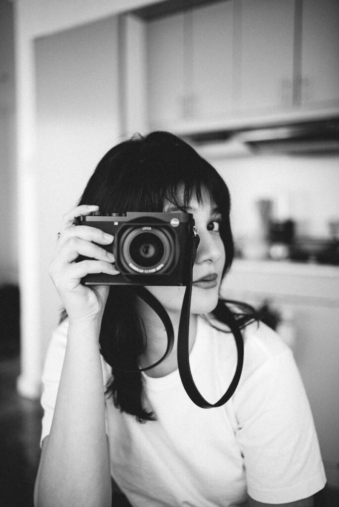 Woman holding a camera in front of her face